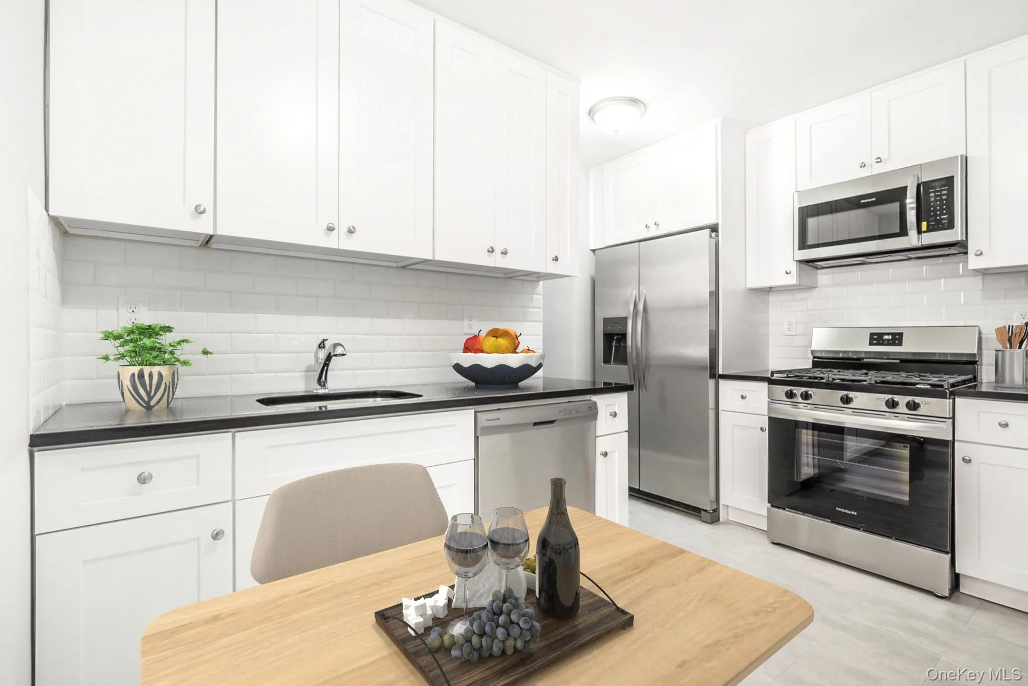 Kitchen with appliances with stainless steel finishes, white cabinets, dark stone counters, and decorative backsplash Kitchen with appliances with stainless steel finishes, white cabinets, dark stone counters, and decorative backsplash