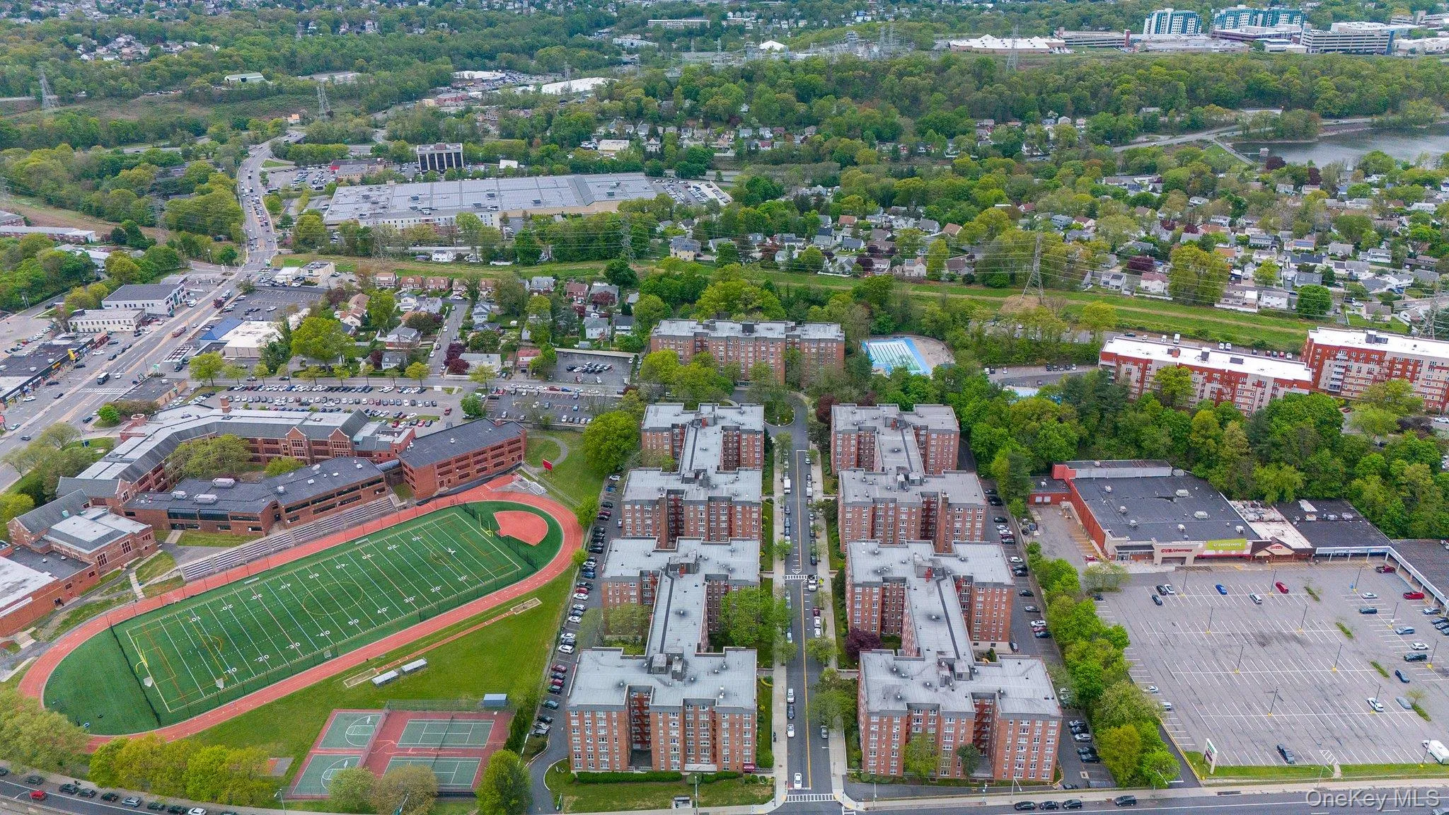 Aerial view of property and surrounding area with nearby urban area and a tree filled landscape Aerial view of property and surrounding area with nearby urban area and a tree filled landscape