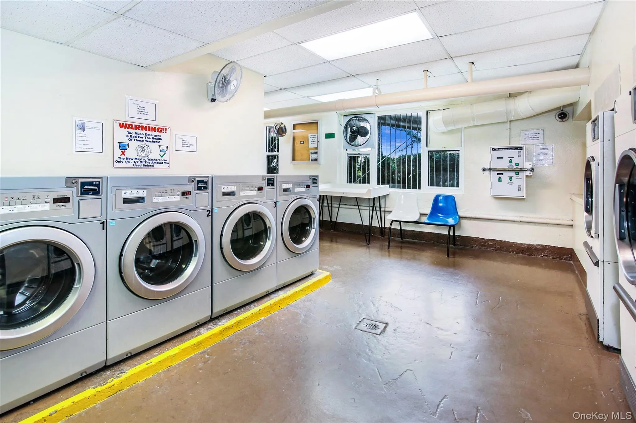 Communal laundry room with washer and clothes dryer and a paneled ceiling Communal laundry room with washer and clothes dryer and a paneled ceiling