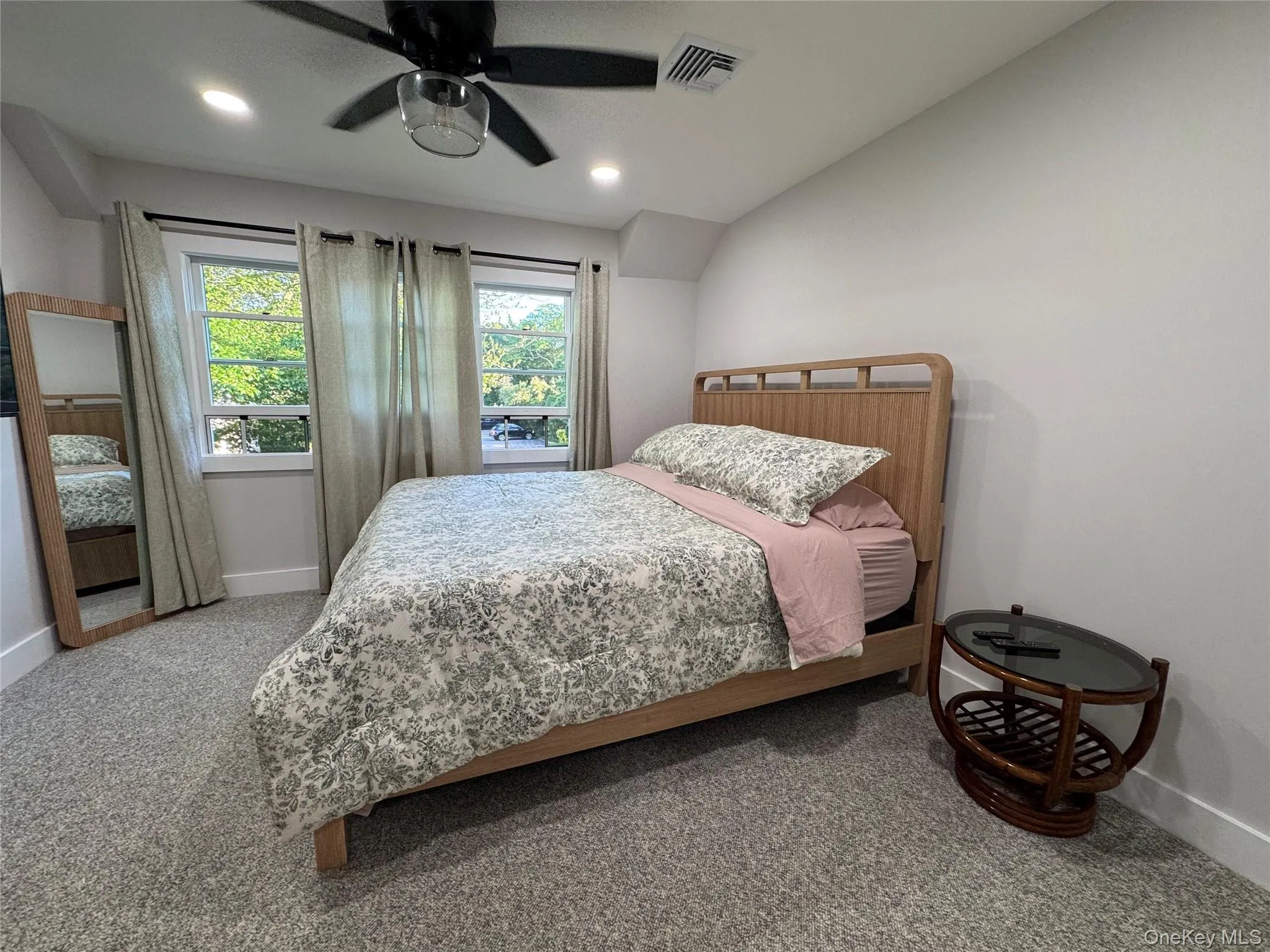 Carpeted bedroom featuring ceiling fan, recessed lighting, and vaulted ceiling Carpeted bedroom featuring ceiling fan, recessed lighting, and vaulted ceiling