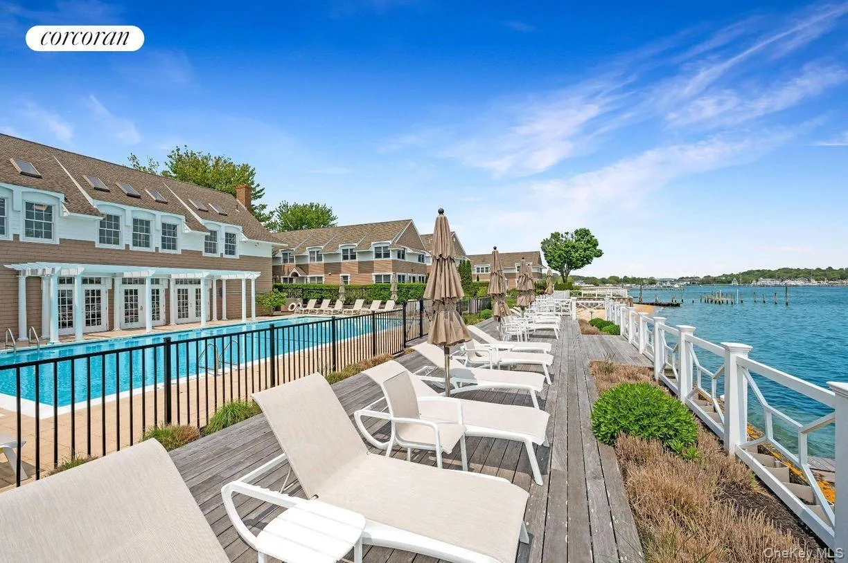 Community pool with a patio area, a deck with water view, and french doors Community pool with a patio area, a deck with water view, and french doors