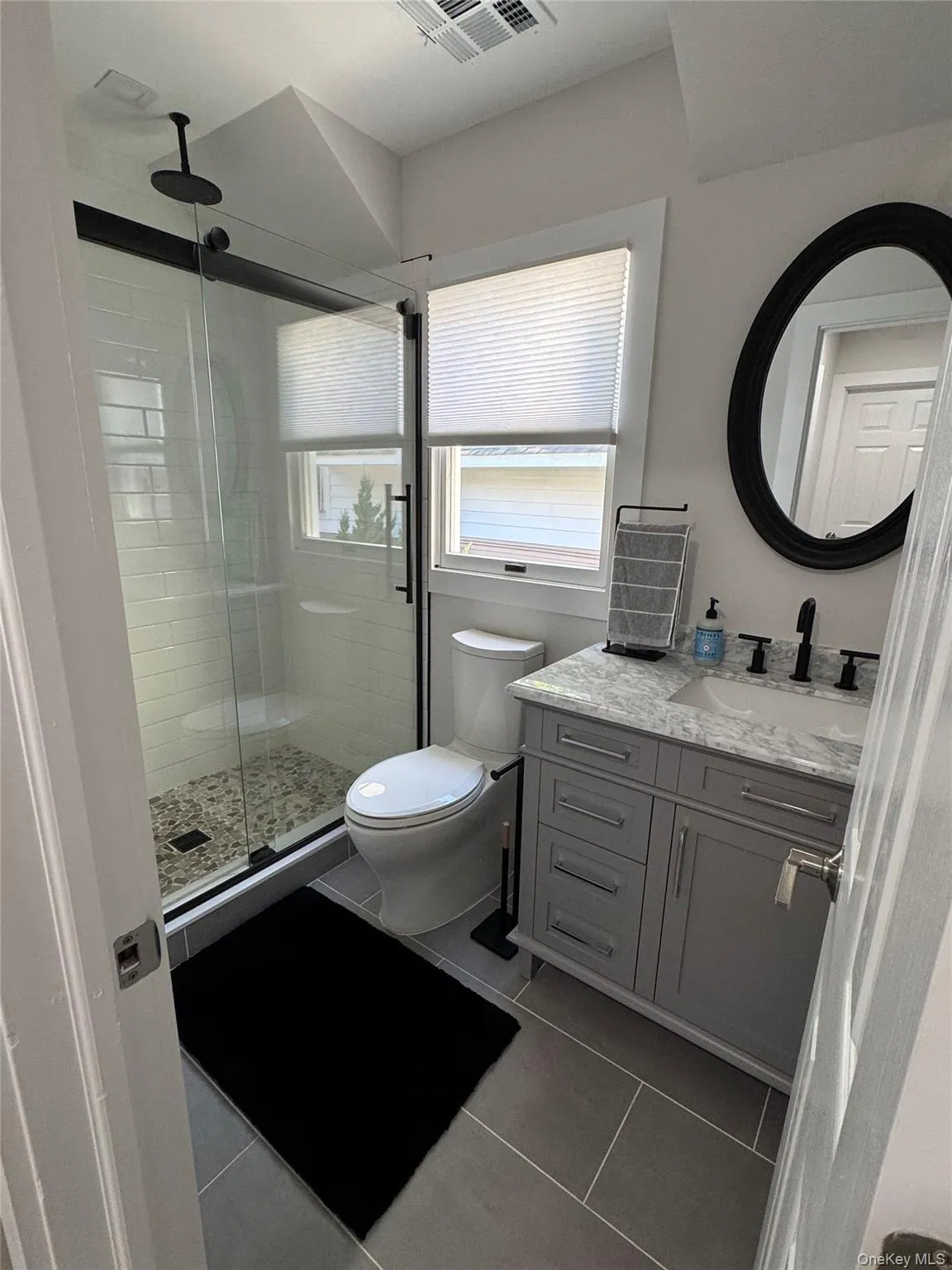 Bathroom with vanity, light tile patterned floors, and a shower stall Bathroom with vanity, light tile patterned floors, and a shower stall