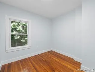 Empty room featuring wood-type flooring and baseboards Empty room featuring wood-type flooring and baseboards