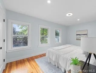 Bedroom with multiple windows, light wood-type flooring, and recessed lighting Bedroom with multiple windows, light wood-type flooring, and recessed lighting