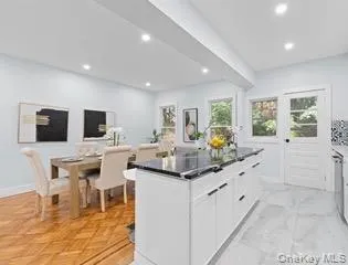 Kitchen with white cabinetry, recessed lighting, a center island, and beamed ceiling Kitchen with white cabinetry, recessed lighting, a center island, and beamed ceiling