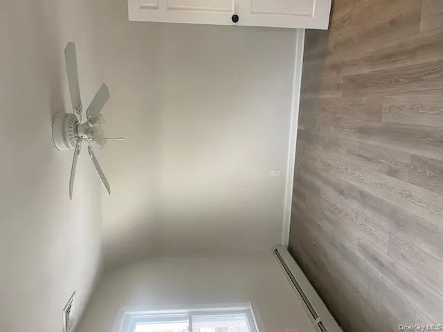 Spare room with baseboard heating, light wood-type flooring, ceiling fan, and lofted ceiling Spare room with baseboard heating, light wood-type flooring, ceiling fan, and lofted ceiling
