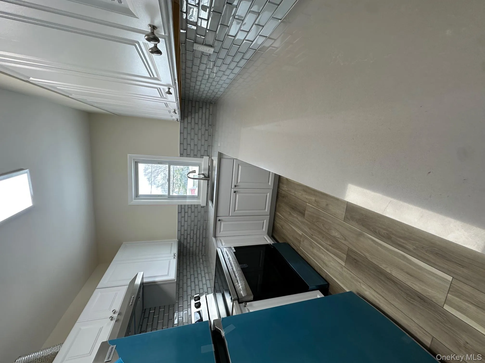 Kitchen with white cabinets, range, fridge, light stone counters, and light wood-style floors Kitchen with white cabinets, range, fridge, light stone counters, and light wood-style floors