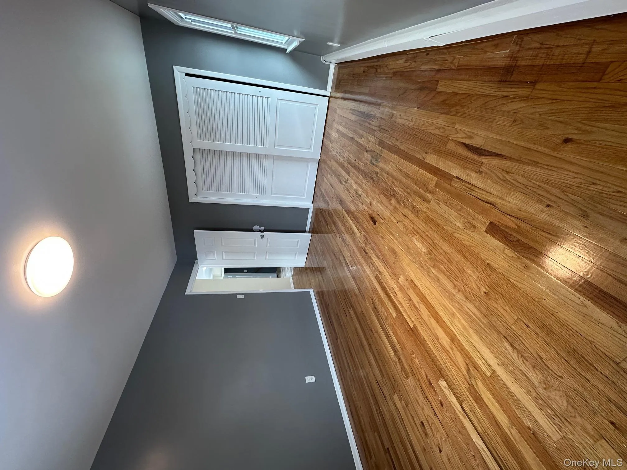 Unfurnished bedroom with light wood-style floors, a closet, and a baseboard radiator Unfurnished bedroom with light wood-style floors, a closet, and a baseboard radiator