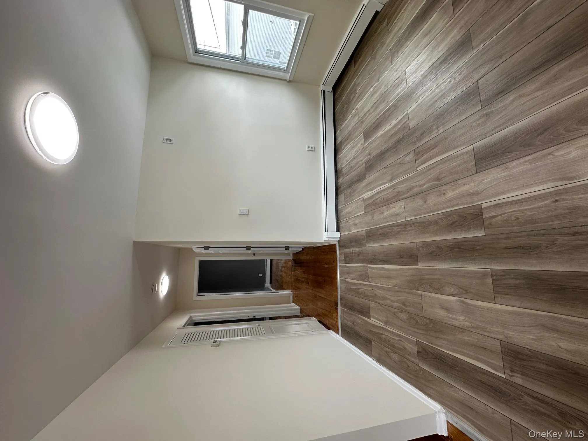 Unfurnished room featuring dark wood-style floors and baseboard heating Unfurnished room featuring dark wood-style floors and baseboard heating