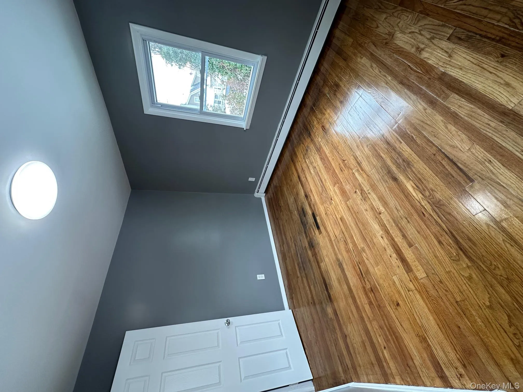 Spare room featuring baseboard heating and hardwood / wood-style floors Spare room featuring baseboard heating and hardwood / wood-style floors