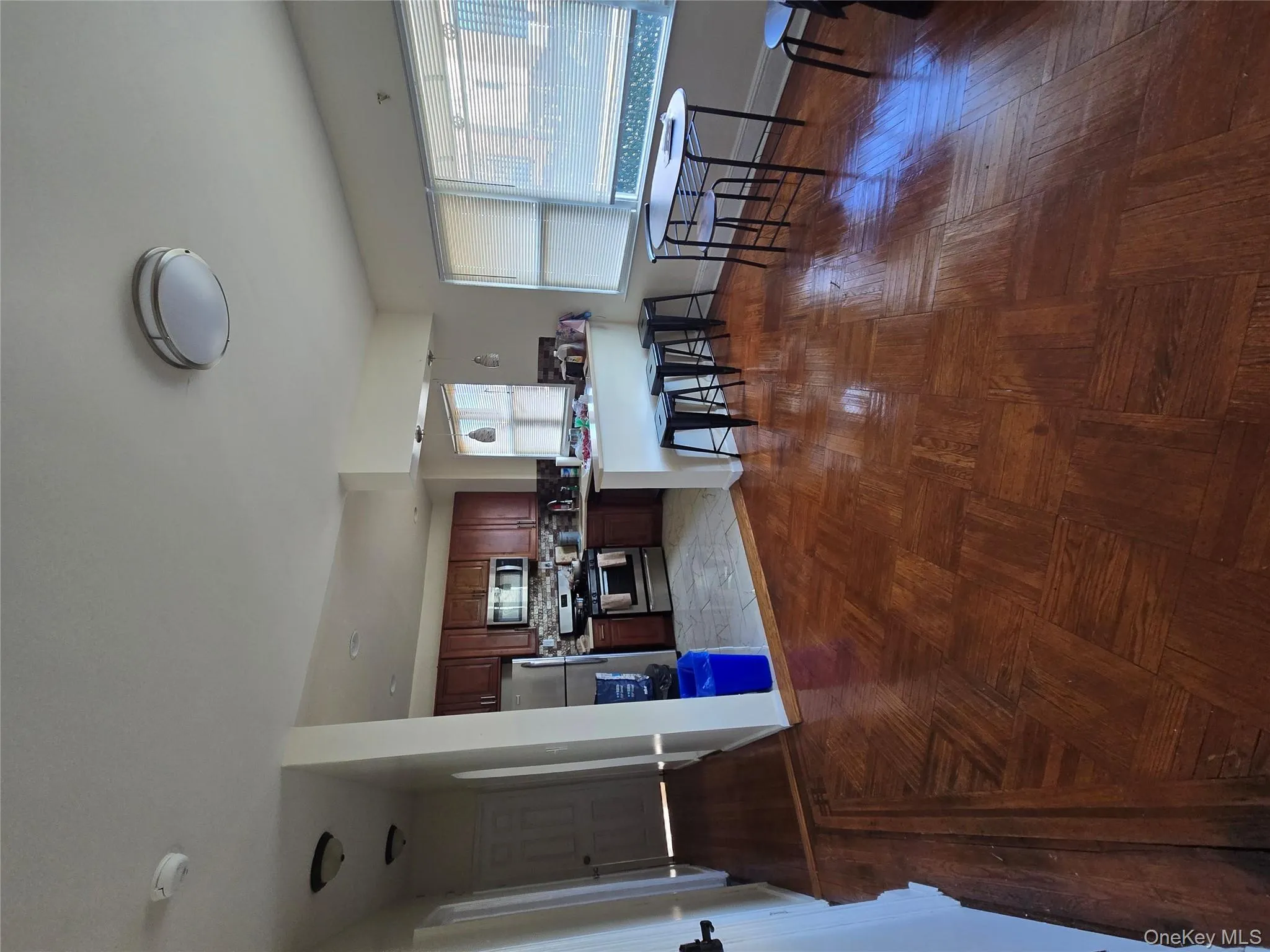 Kitchen featuring stove, a peninsula, fridge, a kitchen bar, and light countertops Kitchen featuring stove, a peninsula, fridge, a kitchen bar, and light countertops