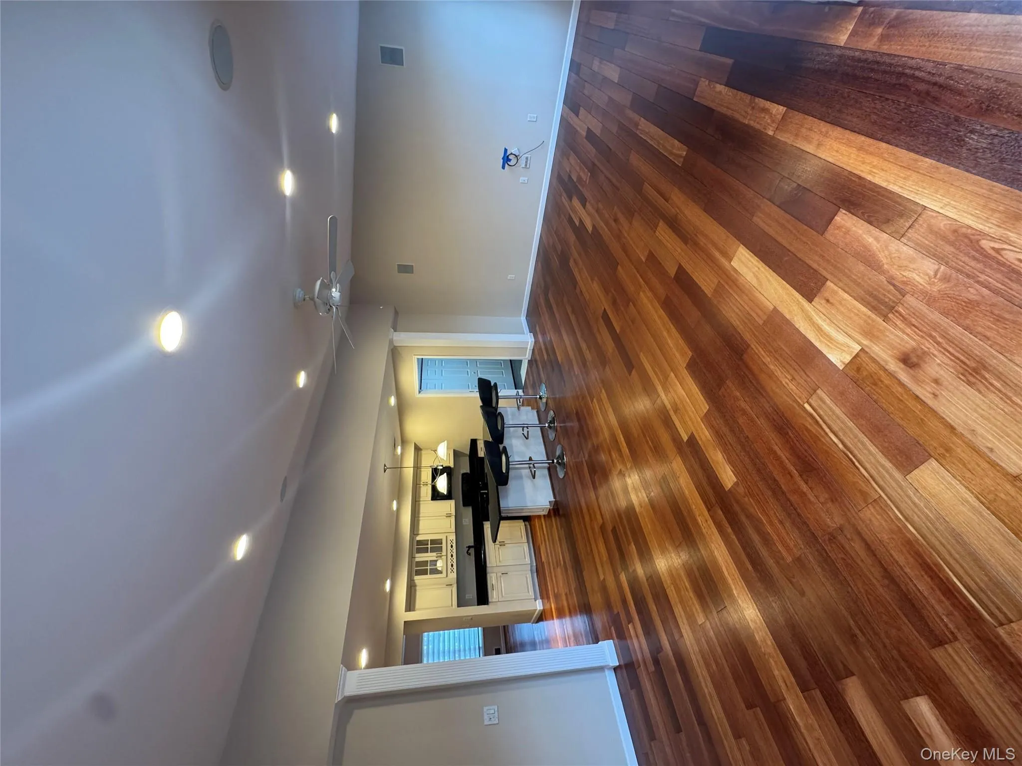 Unfurnished living room featuring dark wood-type flooring, ceiling fan, and recessed lighting Unfurnished living room featuring dark wood-type flooring, ceiling fan, and recessed lighting