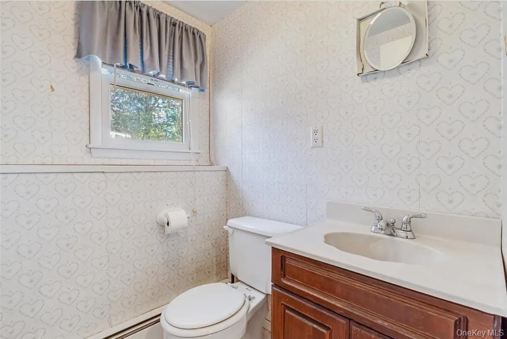 Half bath featuring vanity and baseboard heating Half bath featuring vanity and baseboard heating