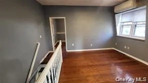 Empty room with dark wood-type flooring and baseboards Empty room with dark wood-type flooring and baseboards