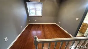 Unfurnished room featuring dark wood-style flooring and lofted ceiling Unfurnished room featuring dark wood-style flooring and lofted ceiling