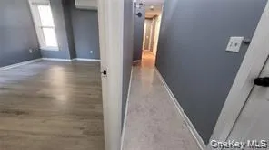 Hall with baseboards and wood finished floors Hall with baseboards and wood finished floors