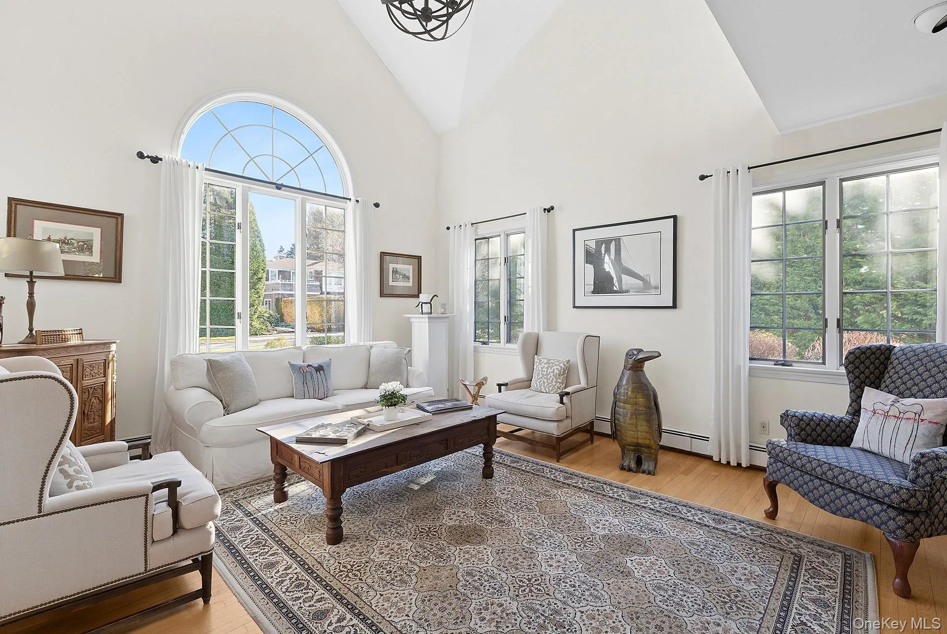 Living room featuring high vaulted ceiling and light wood-type flooring Living room featuring high vaulted ceiling and light wood-type flooring