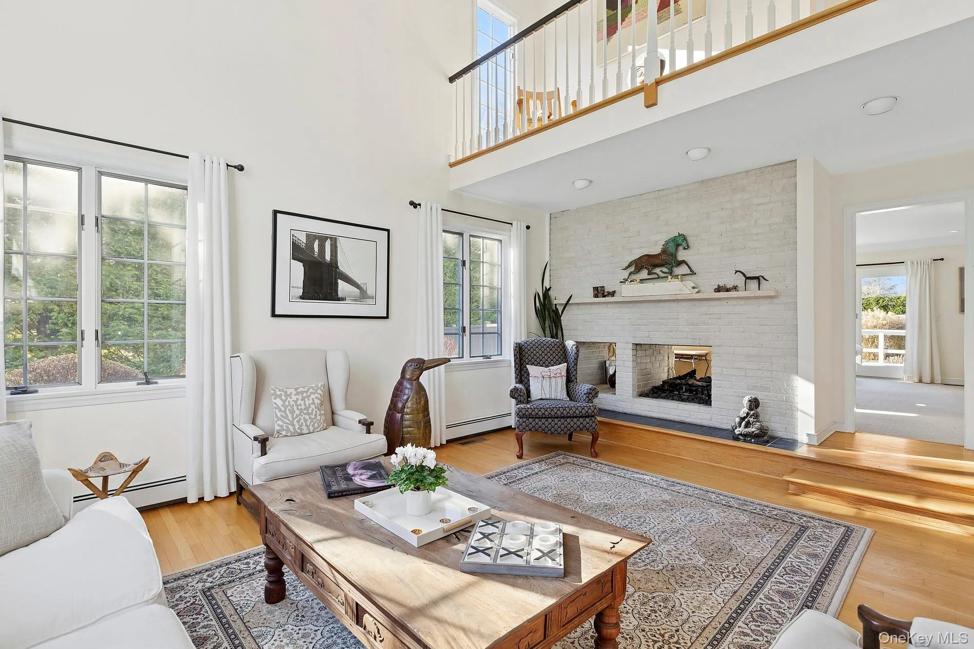 Living area with a brick fireplace, baseboard heating, and wood finished floors Living area with a brick fireplace, baseboard heating, and wood finished floors