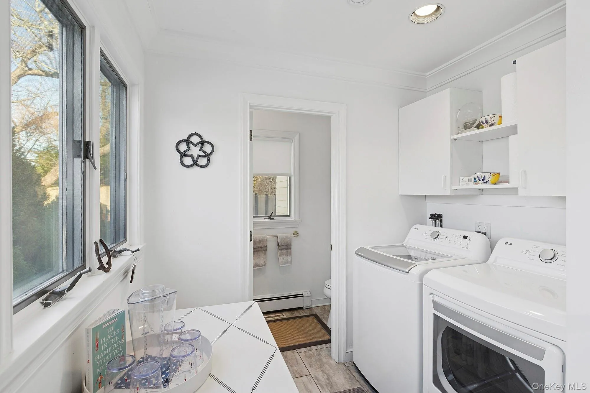 Laundry area with ornamental molding, independent washer and dryer, light wood-style floors, a baseboard heating unit, and recessed lighting Laundry area with ornamental molding, independent washer and dryer, light wood-style floors, a baseboard heating unit, and recessed lighting