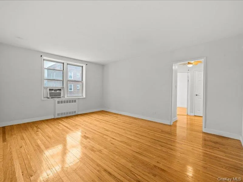 Spare room featuring light wood-style flooring and radiator Spare room featuring light wood-style flooring and radiator