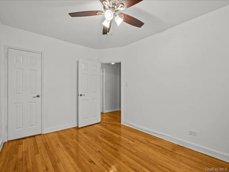 Unfurnished bedroom with a ceiling fan and light wood finished floors Unfurnished bedroom with a ceiling fan and light wood finished floors