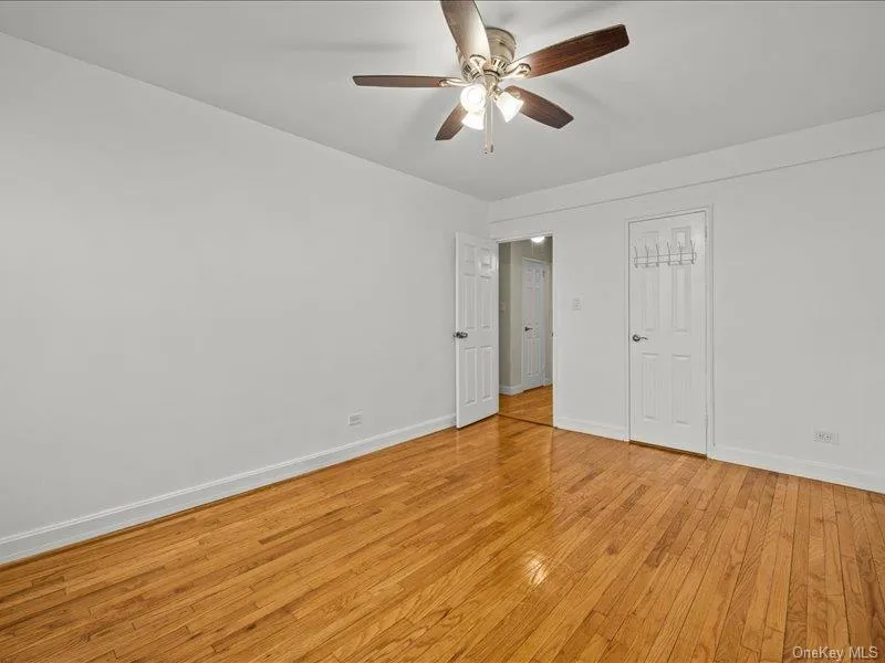 Unfurnished bedroom with light wood finished floors and ceiling fan Unfurnished bedroom with light wood finished floors and ceiling fan