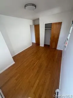 Unfurnished bedroom featuring wood finished floors and a closet Unfurnished bedroom featuring wood finished floors and a closet