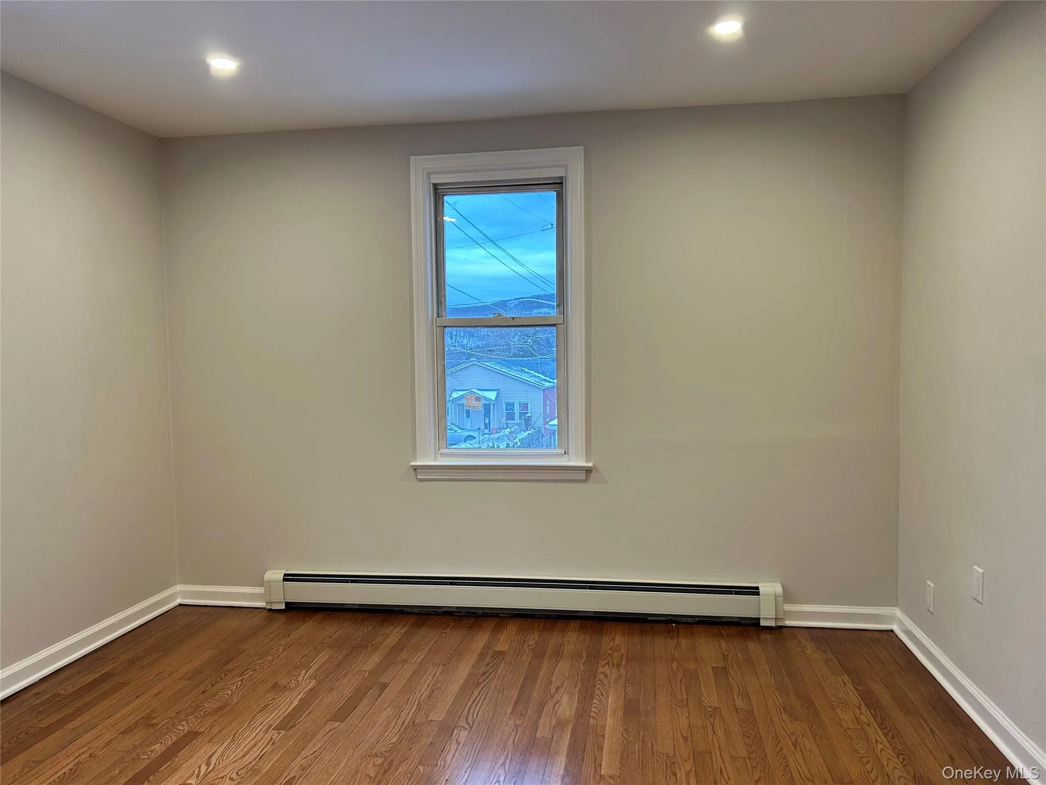 Bedroom with dark wood-type flooring, baseboard heating, and recessed lighting Bedroom with dark wood-type flooring, baseboard heating, and recessed lighting