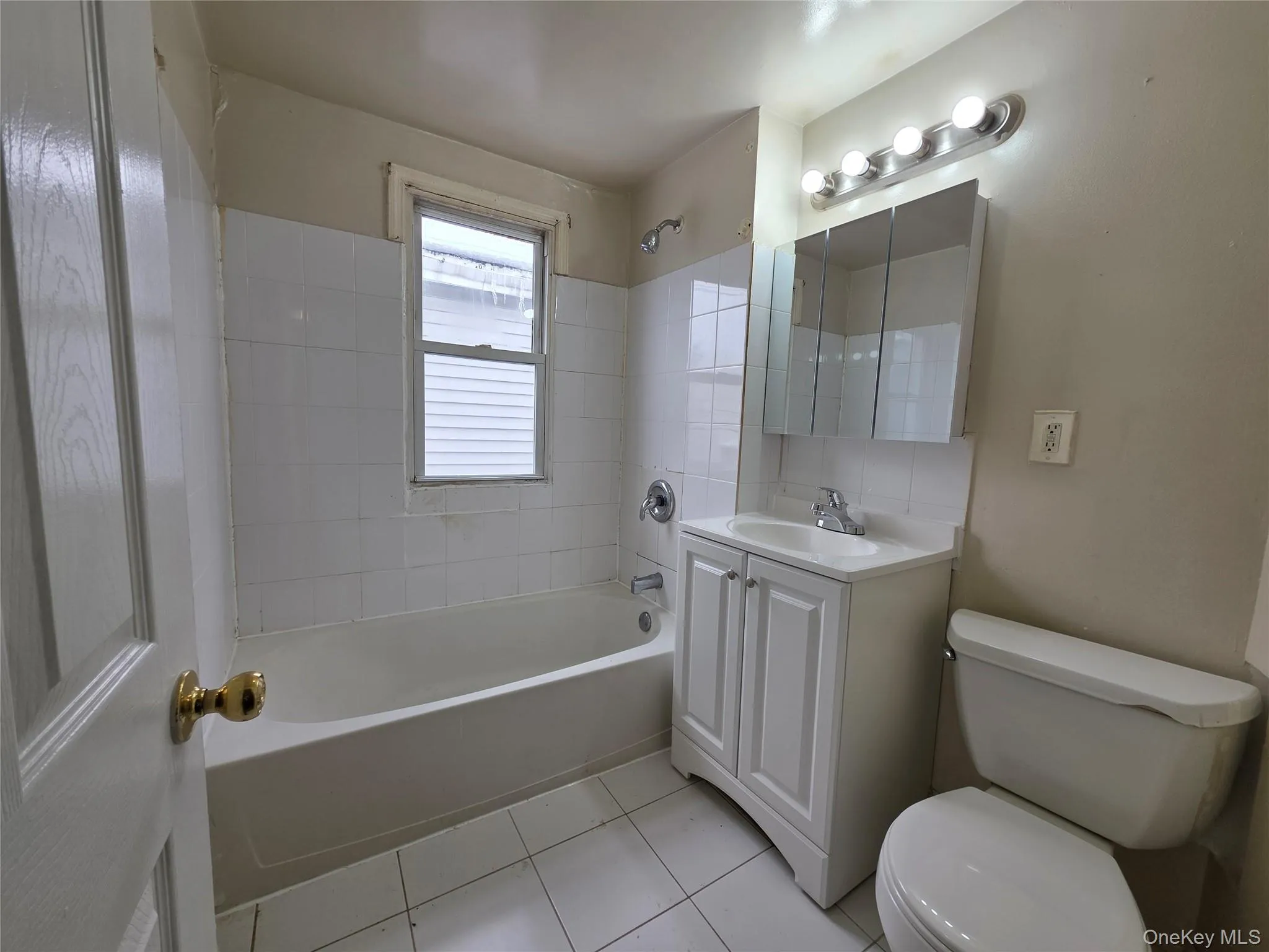 Full bath featuring bathing tub / shower combination, vanity, and light tile patterned flooring Full bath featuring bathing tub / shower combination, vanity, and light tile patterned flooring