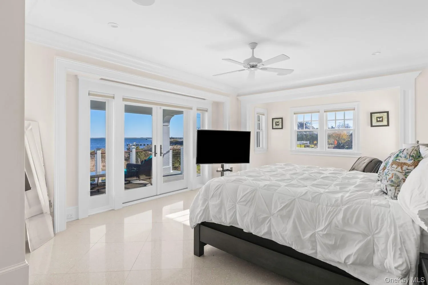 Bedroom with dark aggregate flooring, access to exterior, a ceiling fan, crown molding, and french doors Bedroom with dark aggregate flooring, access to exterior, a ceiling fan, crown molding, and french doors
