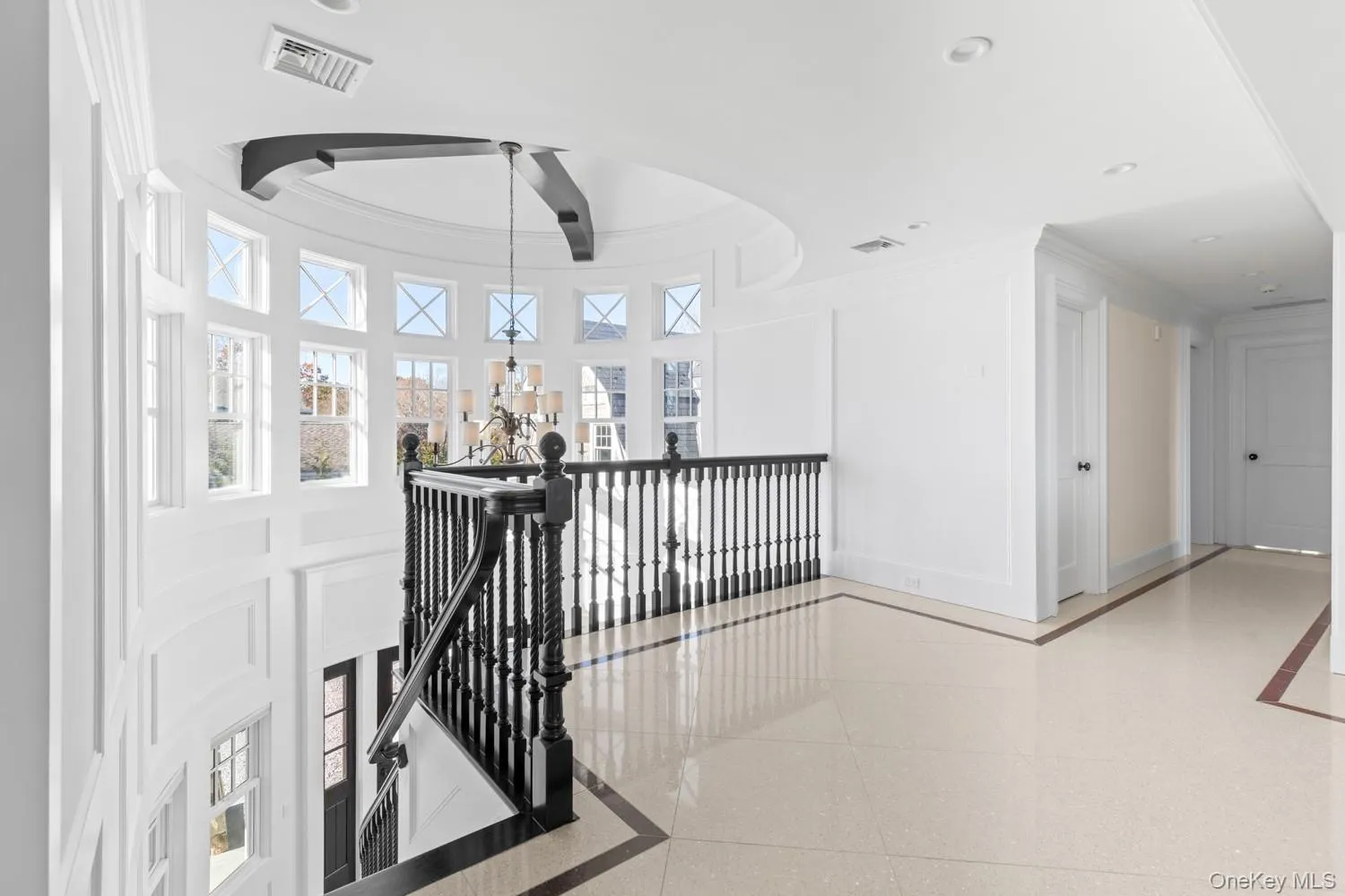 Corridor featuring an upstairs landing, ornamental molding, and inlaid floor details Corridor featuring an upstairs landing, ornamental molding, and inlaid floor details