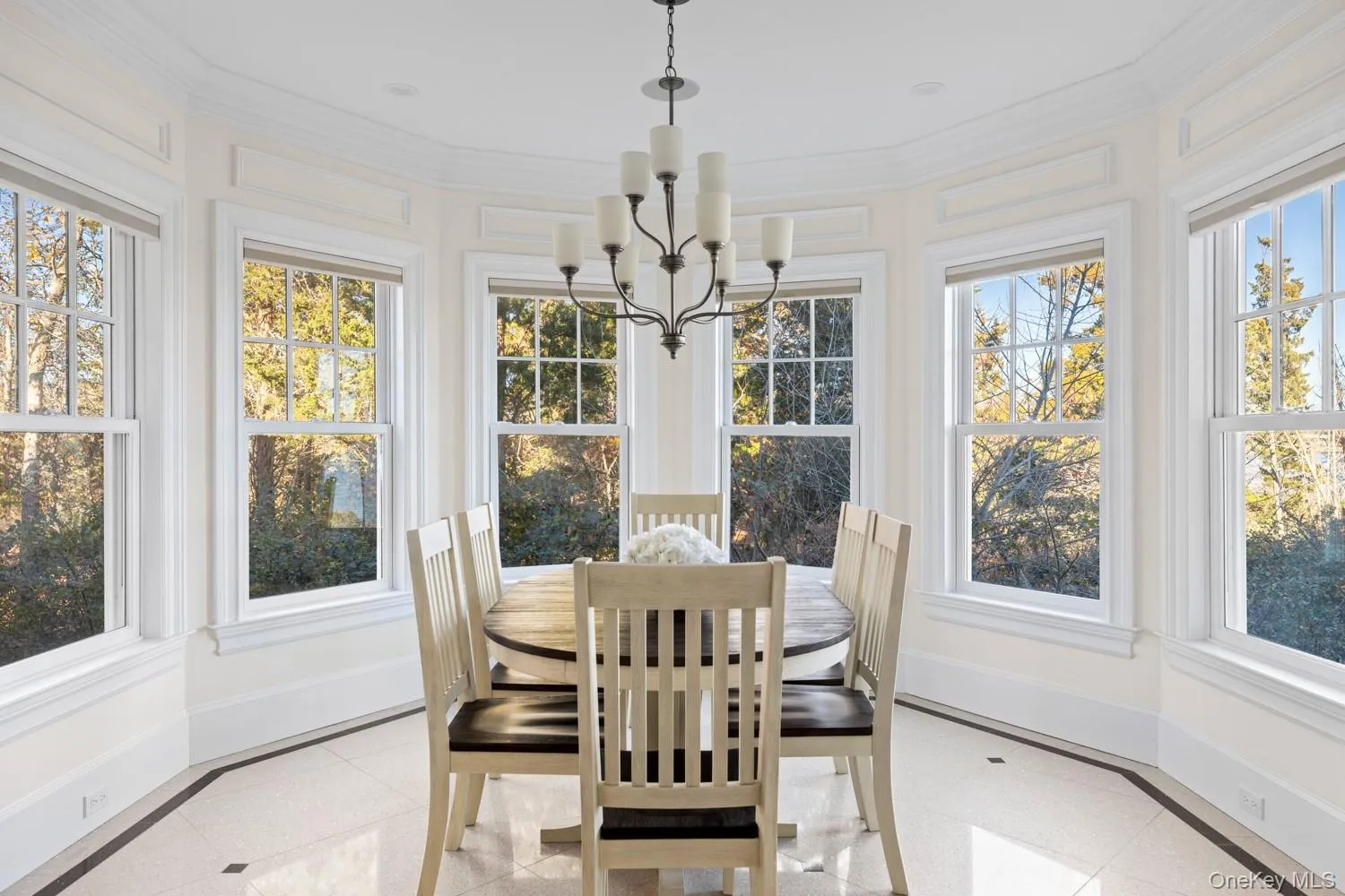 Sunroom with inlaid floor details, a chandelier, and crown molding Sunroom with inlaid floor details, a chandelier, and crown molding