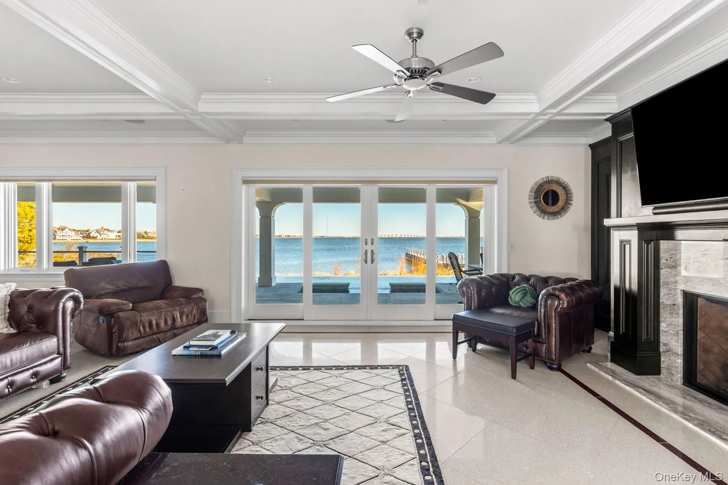 Living room with inlaid floor details, coffered ceiling, french doors, beamed ceiling, and ornamental molding Living room with inlaid floor details, coffered ceiling, french doors, beamed ceiling, and ornamental molding