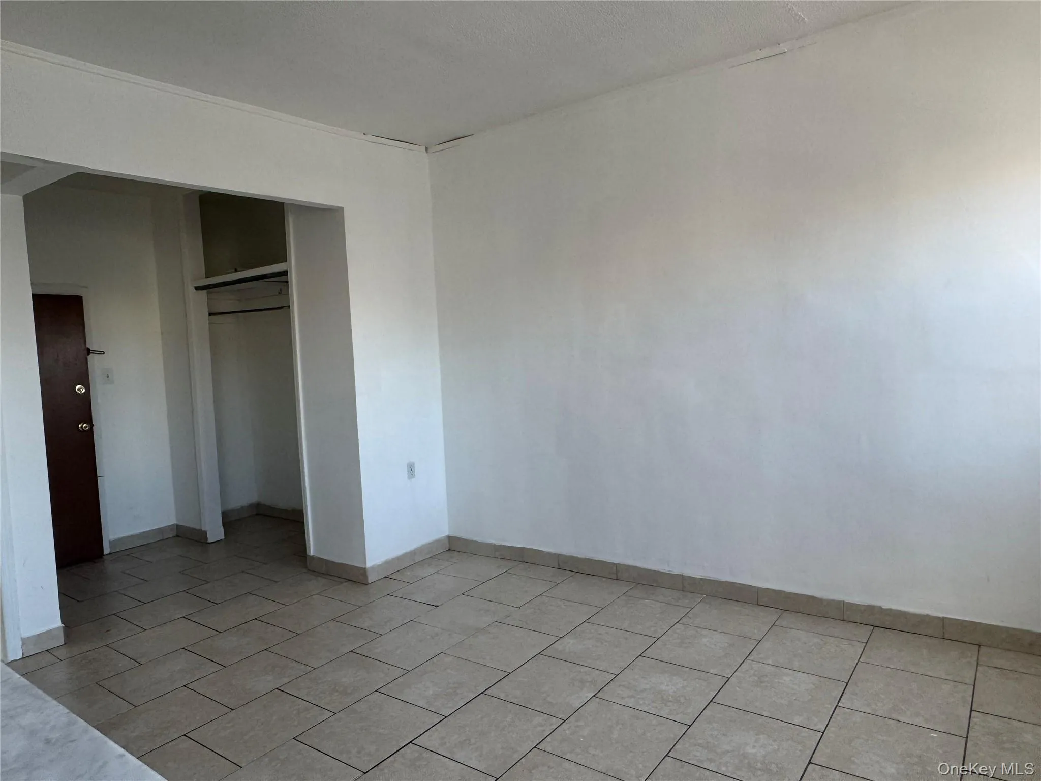 Unfurnished bedroom with a closet and light tile patterned floors Unfurnished bedroom with a closet and light tile patterned floors