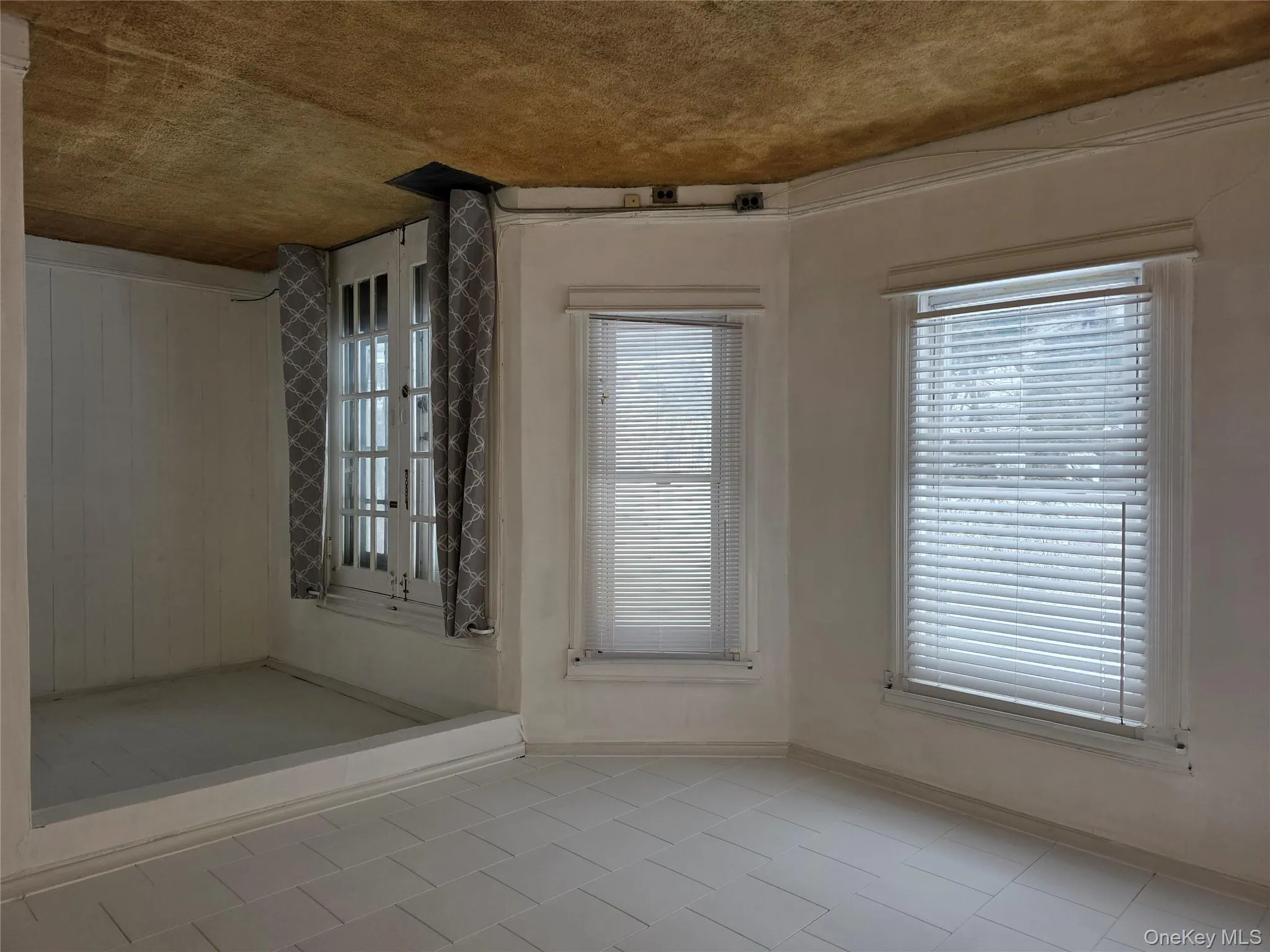 Carpeted spare room with french doors and beam ceiling Carpeted spare room with french doors and beam ceiling