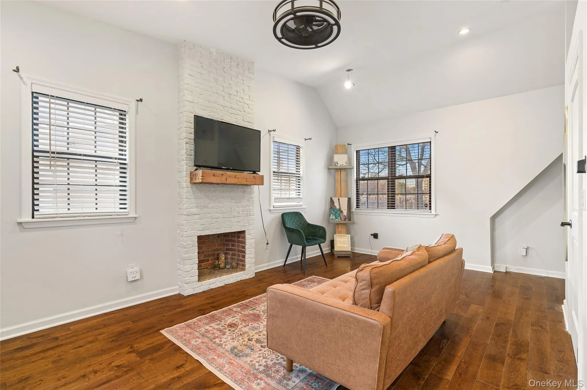 Living room featuring a brick fireplace, lofted ceiling, dark wood finished floors, and recessed lighting Living room featuring a brick fireplace, lofted ceiling, dark wood finished floors, and recessed lighting