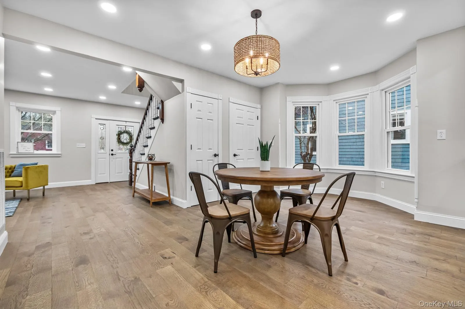Dining room featuring stairs, light wood-type flooring, recessed lighting, and a chandelier Dining room featuring stairs, light wood-type flooring, recessed lighting, and a chandelier