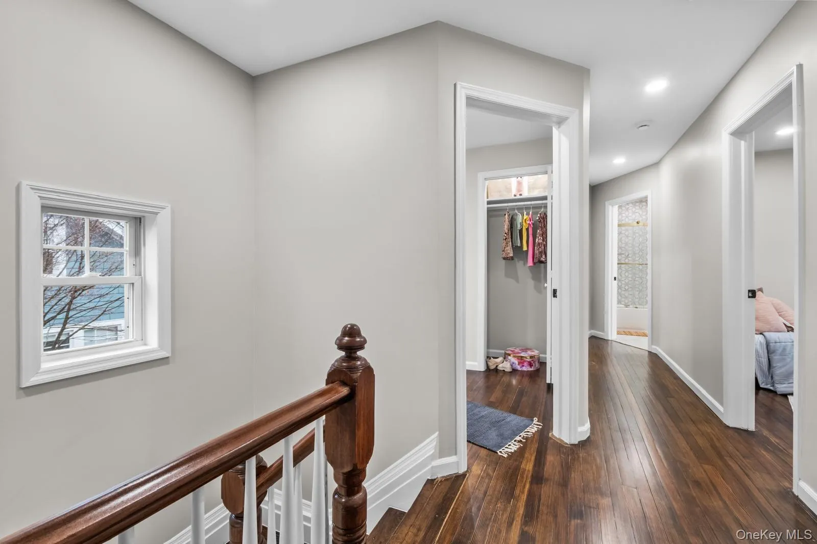 Hall featuring an upstairs landing, dark wood-style flooring, and recessed lighting Hall featuring an upstairs landing, dark wood-style flooring, and recessed lighting