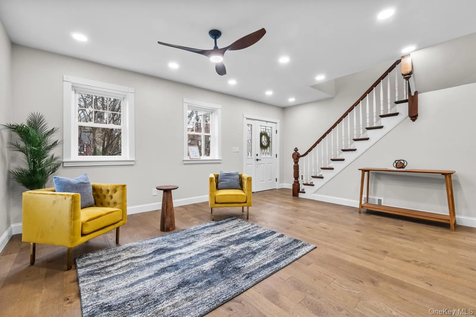 Sitting room with stairs, light wood-style floors, recessed lighting, and a ceiling fan Sitting room with stairs, light wood-style floors, recessed lighting, and a ceiling fan