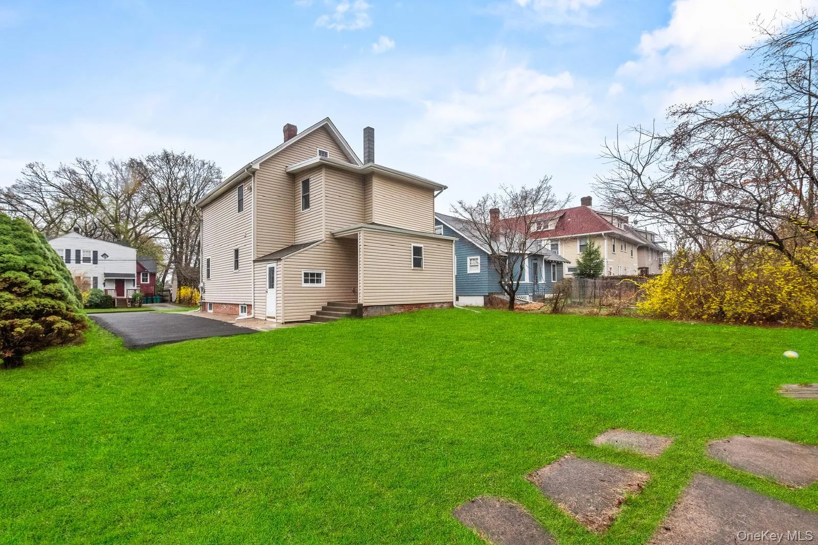 Back of property featuring a chimney, a yard, and entry steps Back of property featuring a chimney, a yard, and entry steps