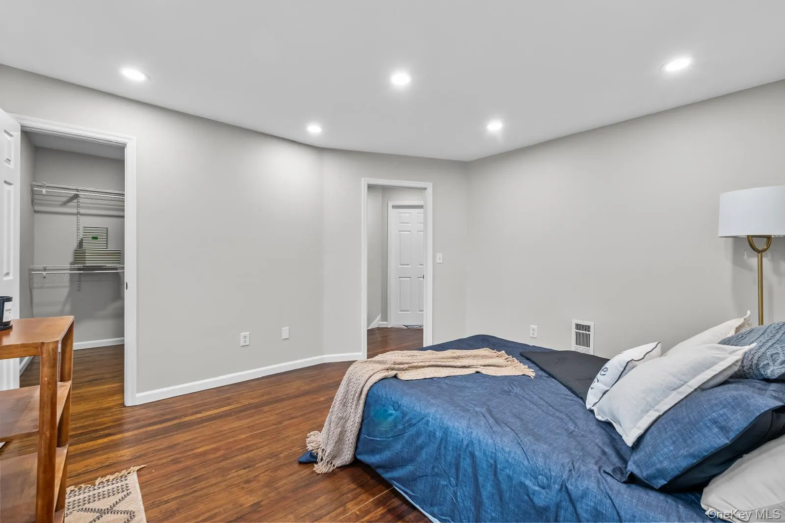 Bedroom with a walk in closet, dark wood-style floors, and recessed lighting Bedroom with a walk in closet, dark wood-style floors, and recessed lighting