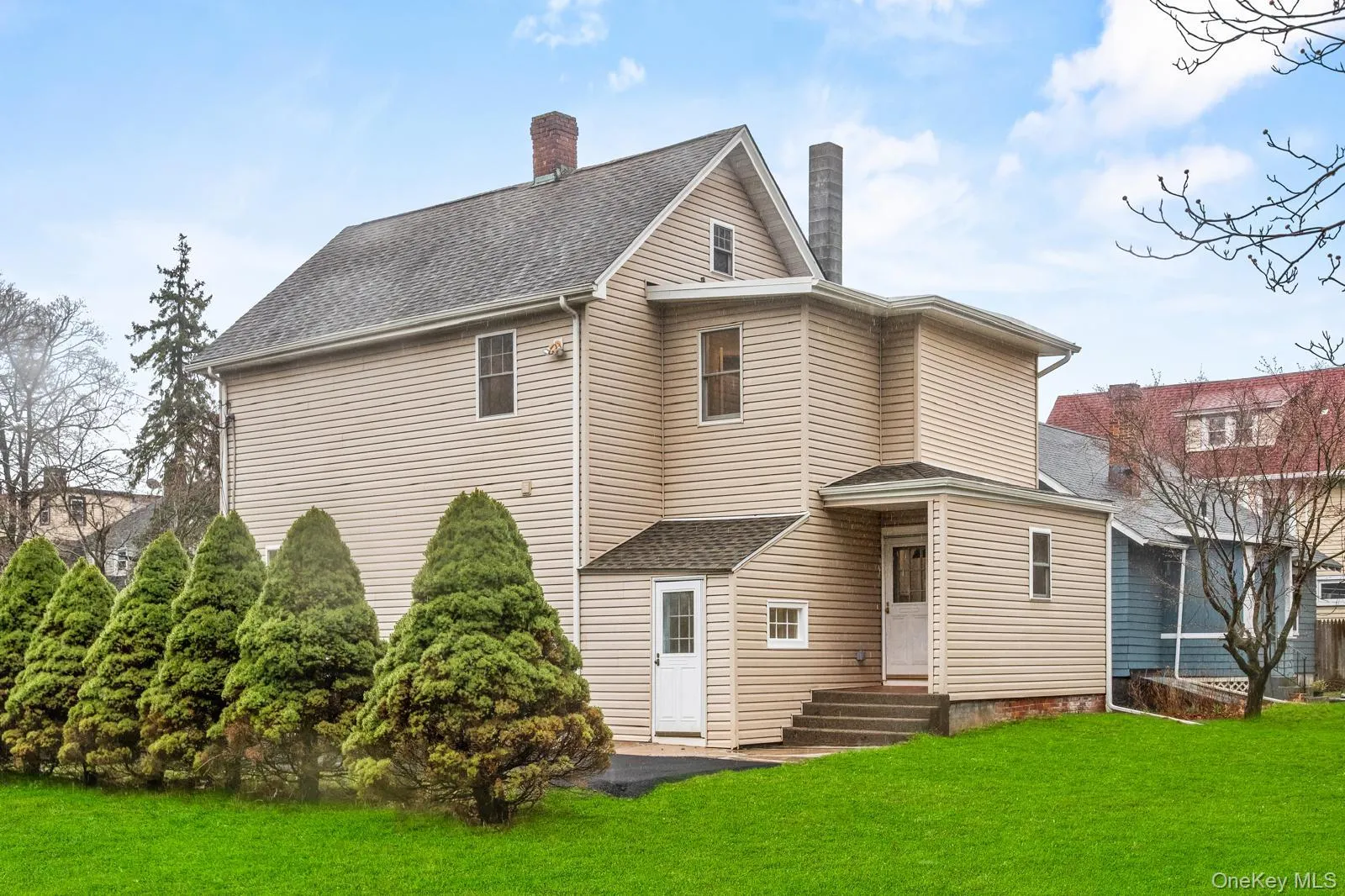 Back of property with a yard, roof with shingles, a chimney, and entry steps Back of property with a yard, roof with shingles, a chimney, and entry steps