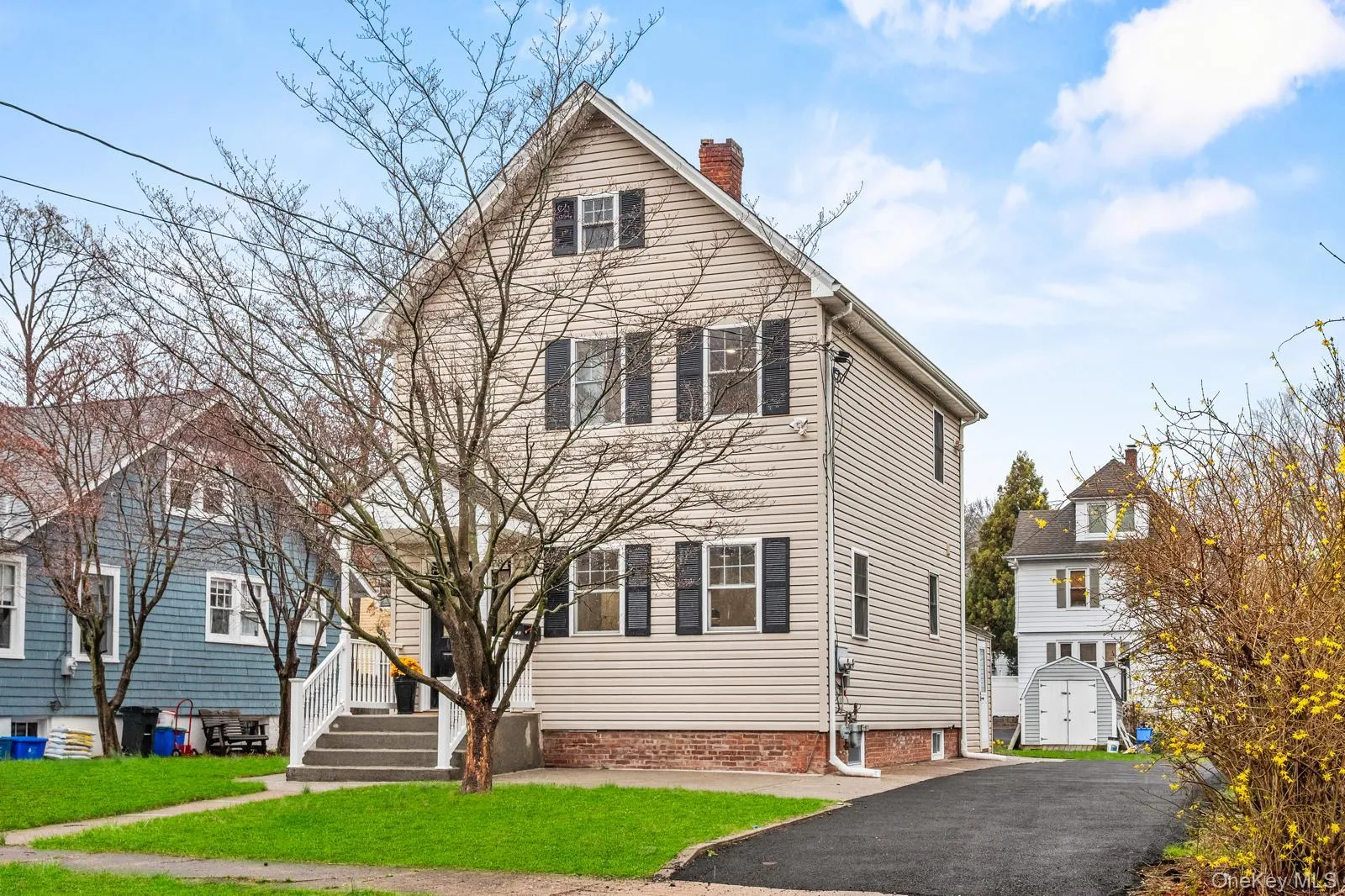 Traditional-style home featuring a chimney, a front yard, and a storage shed Traditional-style home featuring a chimney, a front yard, and a storage shed