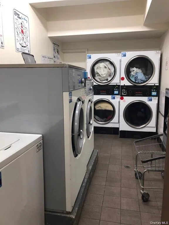 Communal laundry room with stacked washer and clothes dryer and washing machine and dryer Communal laundry room with stacked washer and clothes dryer and washing machine and dryer