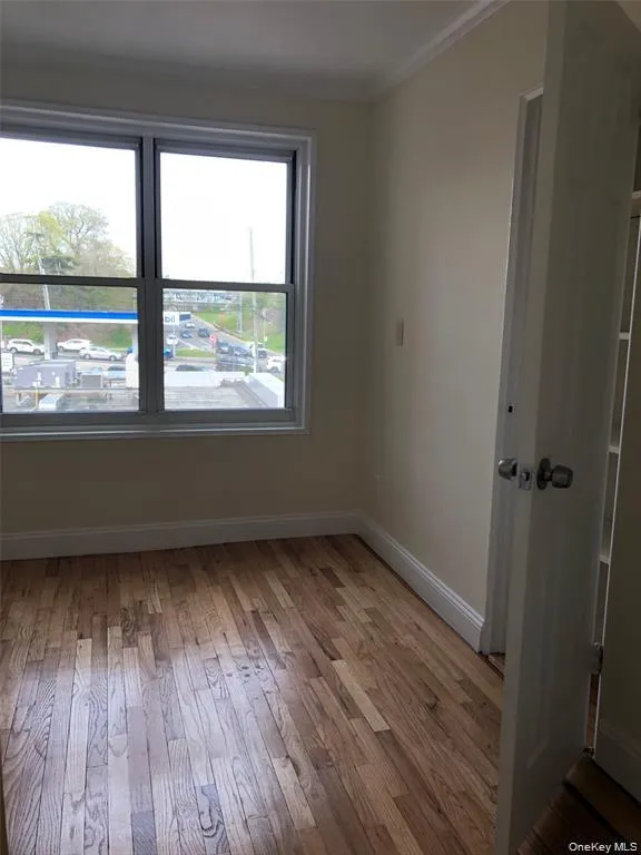 Unfurnished room with light wood-style floors and crown molding Unfurnished room with light wood-style floors and crown molding