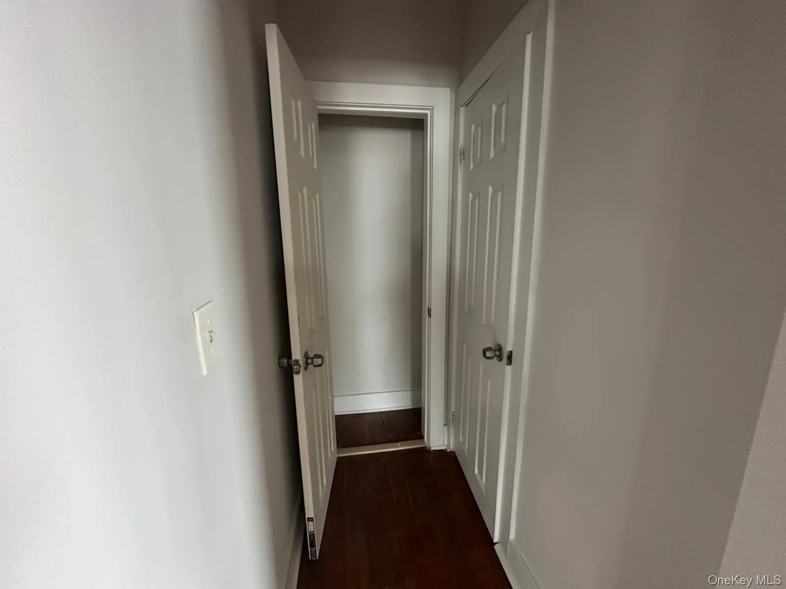 Hallway featuring dark wood-style floors and baseboards Hallway featuring dark wood-style floors and baseboards