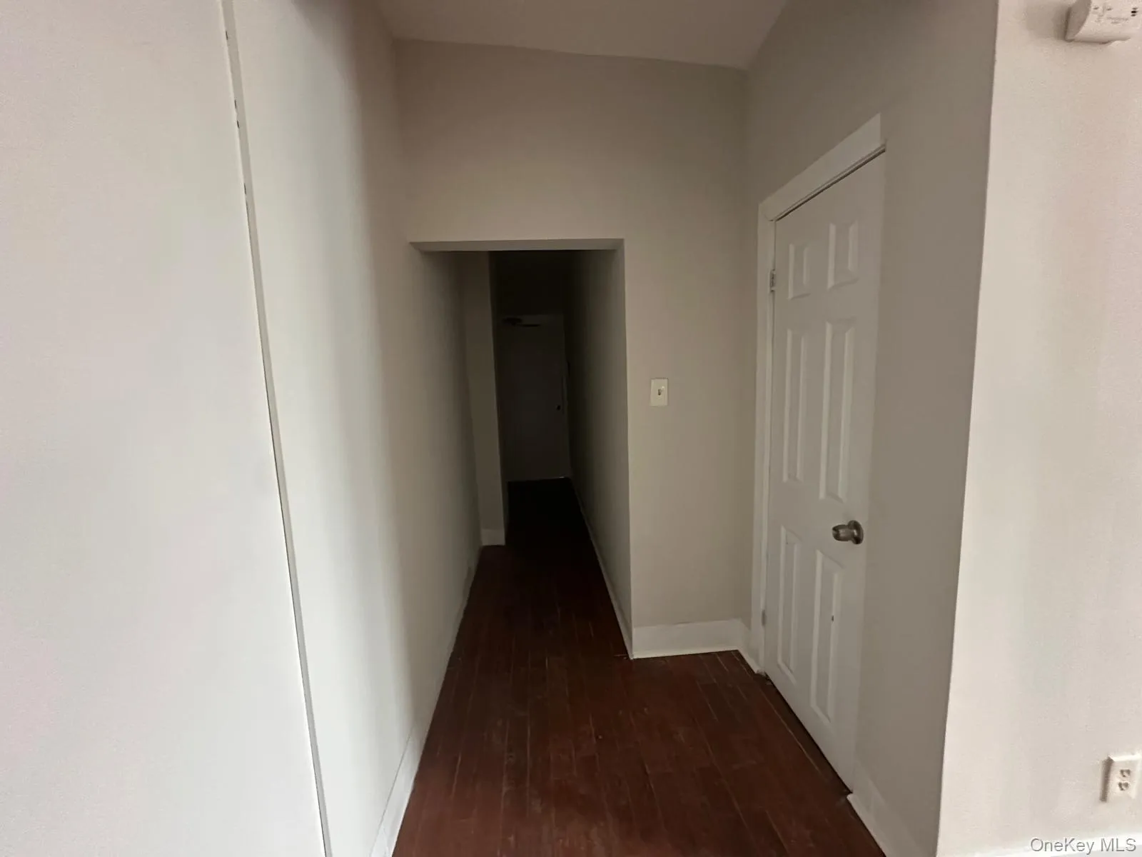 Hall featuring baseboards and dark wood finished floors Hall featuring baseboards and dark wood finished floors