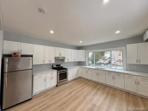 Kitchen with appliances with stainless steel finishes, white cabinets, light countertops, and recessed lighting Kitchen with appliances with stainless steel finishes, white cabinets, light countertops, and recessed lighting