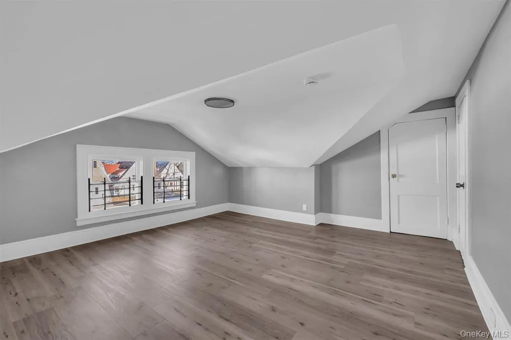 Bonus room featuring light wood finished floors and lofted ceiling Bonus room featuring light wood finished floors and lofted ceiling