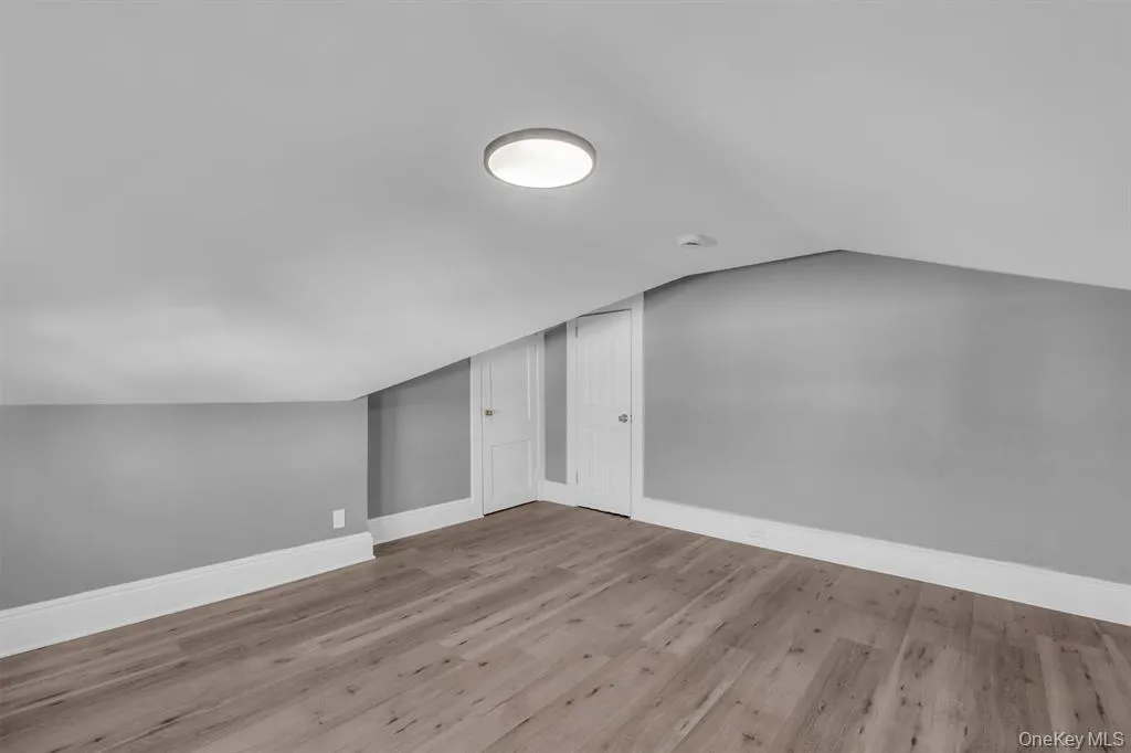 Bonus room featuring light wood-style floors and vaulted ceiling Bonus room featuring light wood-style floors and vaulted ceiling